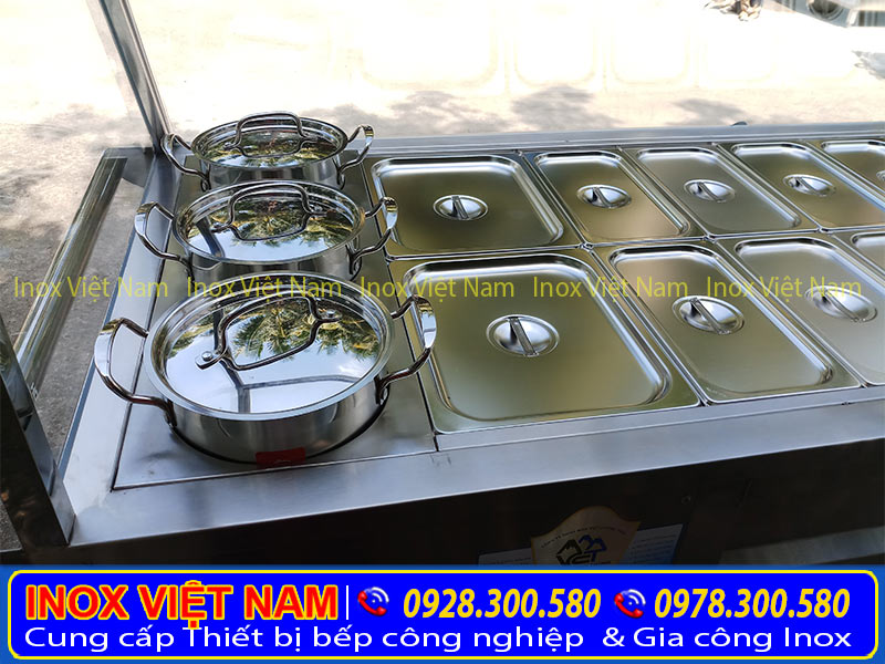 Tủ hâm nóng thức ăn với các khay inox có nắp đậy. Và nồi inox nhìn sang trọng, chất lượng.